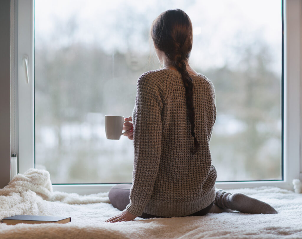 meditation session: woman drinks tea while looking outside