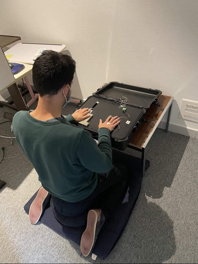 One of the members of the research team is testing his device for evaluating tactile perception in a meditation posture.