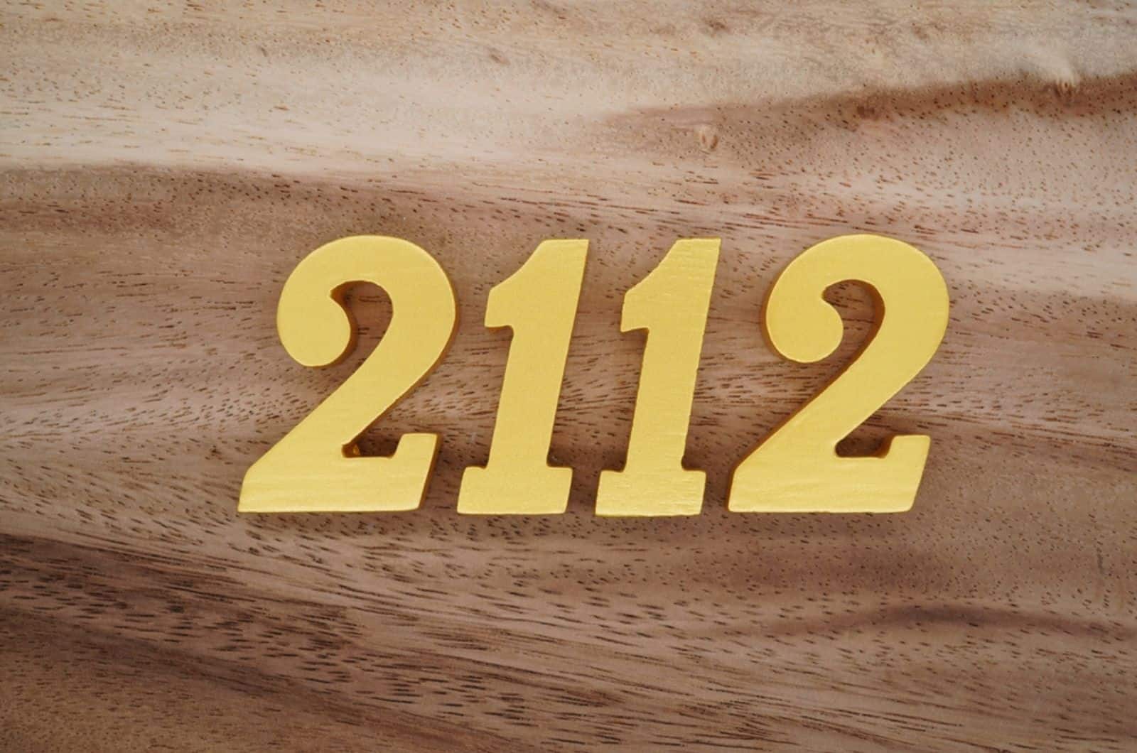 numerals 2112 on a dark brown to white wood