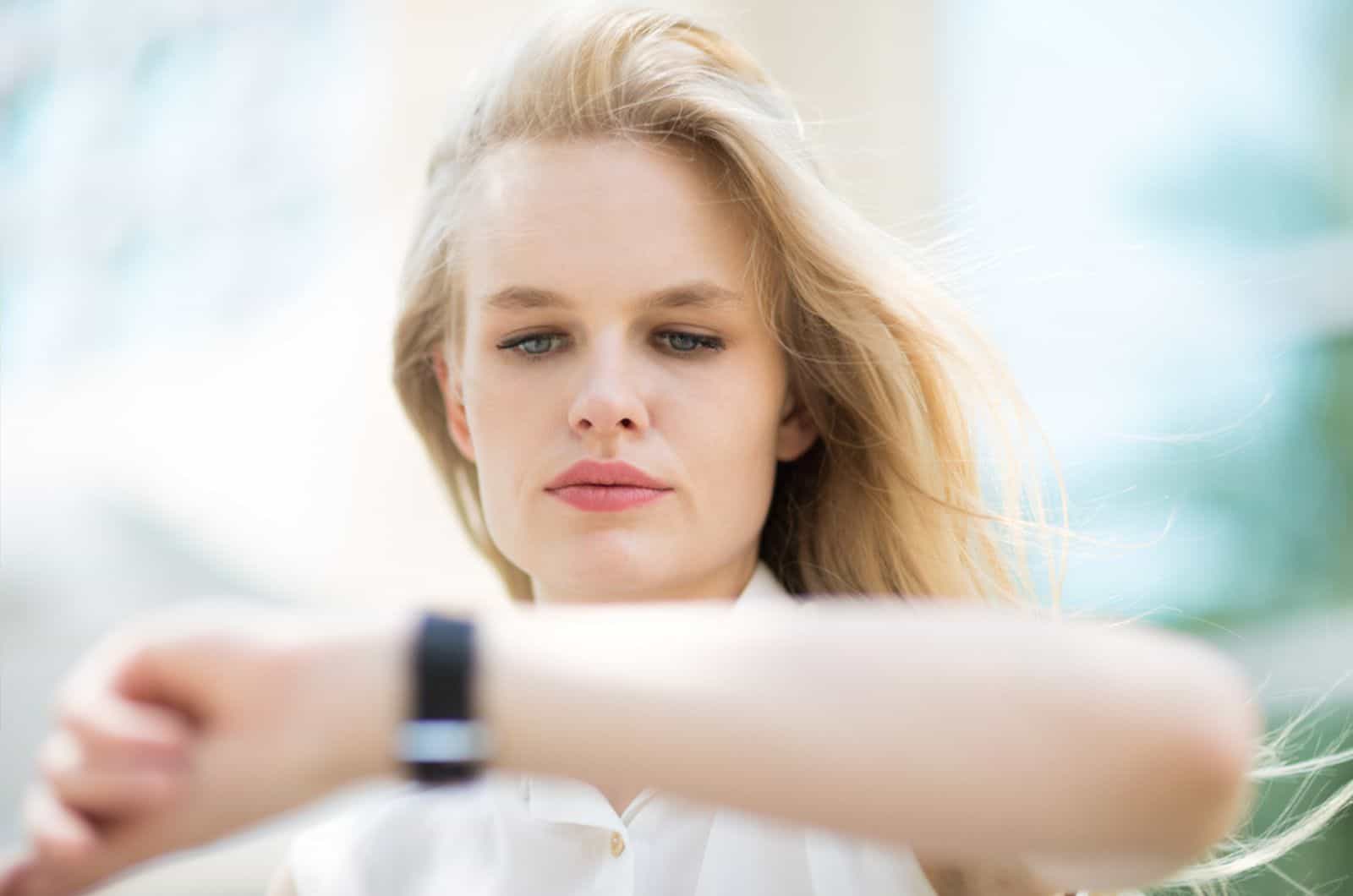 Young businesswoman checking the time on her watch