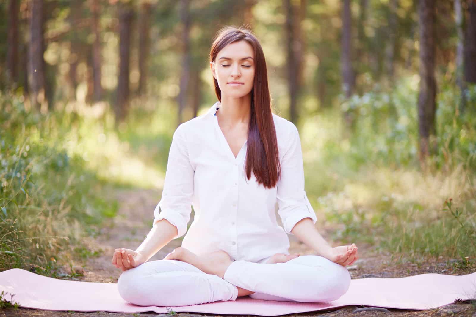 young woman meditates in nature
