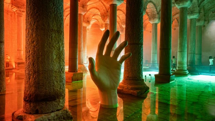 A hand rises from the water in the basilica cistern of Emperor Justinian reopened to the public, on July 26, 2022 in Istanbul, Turkey