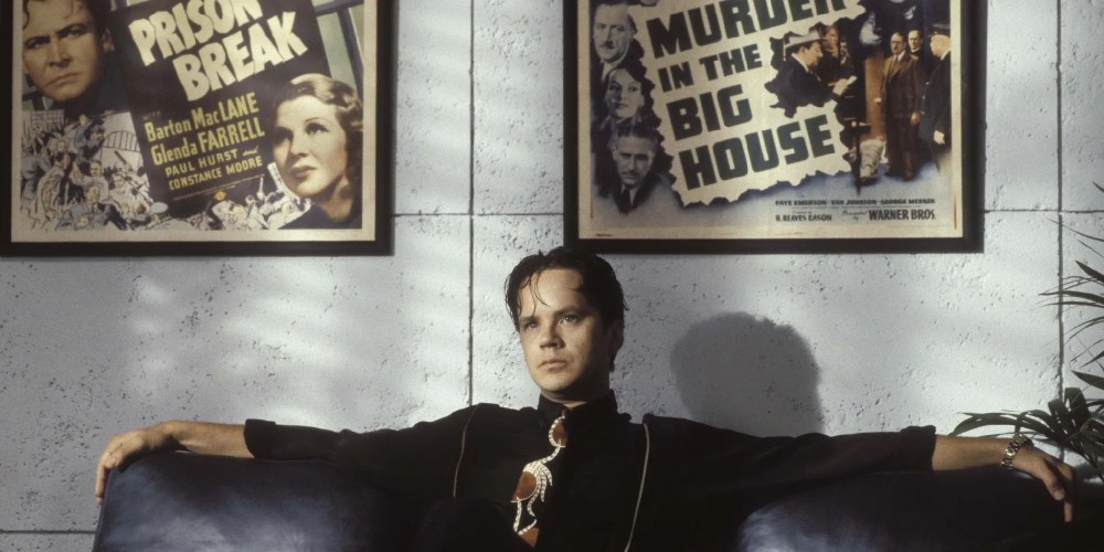 Tim Robbins as Griffin Mill sitting on a couch in The Player